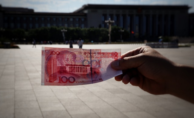 Изображение Человек держит купюру 100 юаней