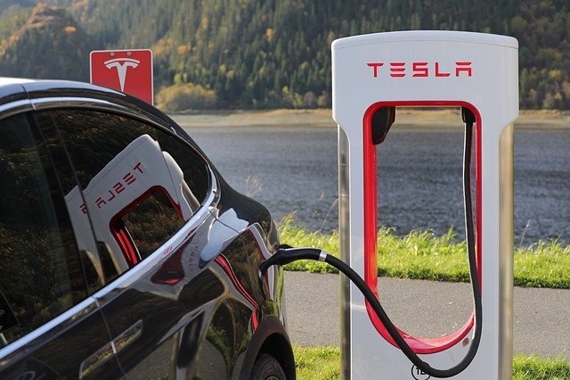 Электромобиль Tesla на заправке Изображение Электромобиль Tesla на заправке